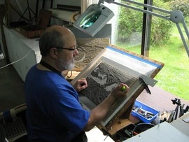 Patrick Simon working closely on a printmaking surface in his studio.